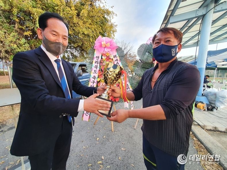 구이OB 서양수 회장이 완주군 축구협회장으로부터 트로피를 수여 받고 있다(사진=데일리연합DB)