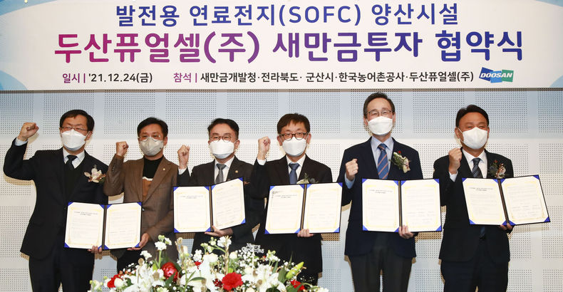 국내 1위 발전용 연료전지 회사인 두산퓨얼셀㈜이 새만금에 1,437억 투자하여 발전용 연료전지 양산시설 건립을 위한 협약식이 24일 군산 은파팰리스에서 열린 가운데 송하진도지사와 제후석 두산퓨얼셀㈜ 전무, 양충모 새만금 개발청장등 참석자들이 협약식을 갖고 기념촬영을 하고 있다. 왼쪽부터 김우상 한국농어촌공사 단장, 신영대 국회의원, 양충모 새만금개발청장, 제후석 두산퓨얼셀㈜ 전무, 송하진 도지사,강임준 군산시장 (사진=전북도청)