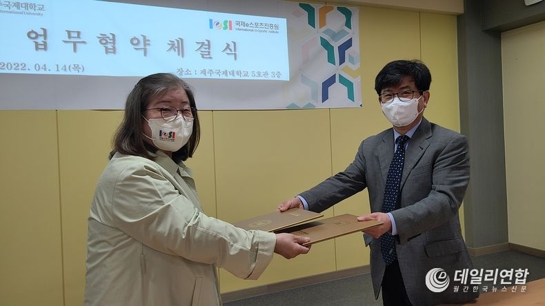업무협약서를 전달하고 있는 국제e스포츠진흥원 전옥이 이사장, 제주국제대학교 강철준 총장