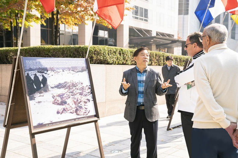 안재철 대표가 광화문을 찾은 외국인들에게 6⸱25전쟁 참상에 대해 설명하고 있다. 