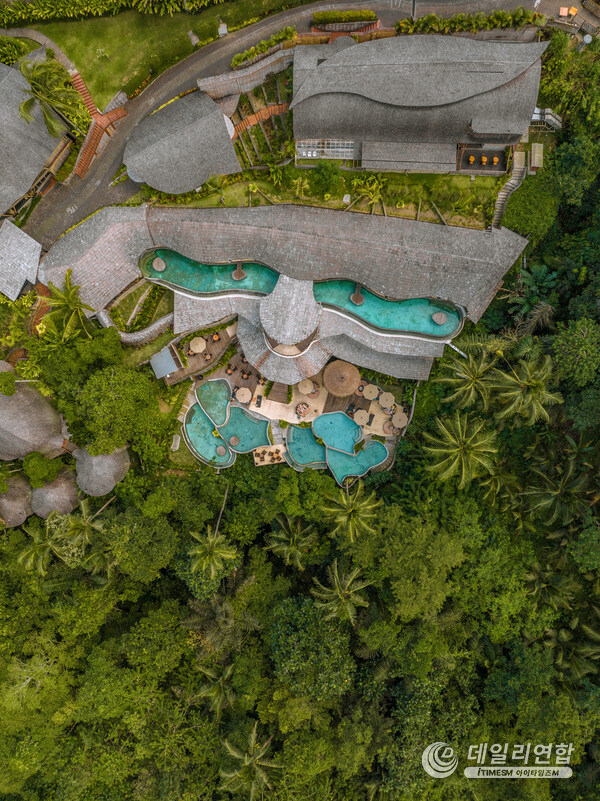 A breathtaking K Club Ubud, revealing its exquisite pool design harmoniously intertwined with lush jungle landscapes, offering guests a refined eco-luxury retreat immersed in the natural beauty of Ubud, Bali.