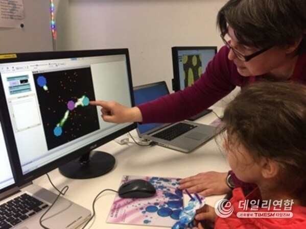 개미가 집단으로 식량을 모으는 방법을 보여주는 넷로고 개미 모델을 조사하는 학생