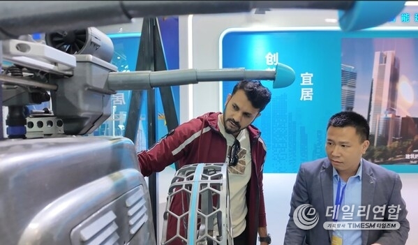 At an exhibition of the 2025 World Cities Day China Observance, a foreign visitor explored the robots and learned about their features and performance. (Photo/Luo Huxin)