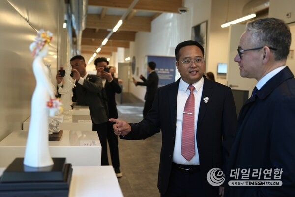 Photo taken on Feb. 24 shows Fang Junqin, Party Chief of Dehua County in southeast China's Fujian Province introducing Dehua white porcelain exhibits to foreigners in Palais des Nations in Geneva, Switzerland.