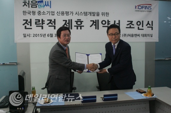 (주)처음앤씨 금상연 대표와 한국금융시스템협회 신근영 회장이 전략적 제휴계약서 체결후 악수를 하고 있다.